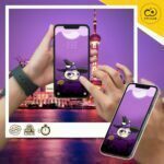 Dos manos sostienen y usan un móvil con el fondo de pantalla de Wachi brujita temática de Halloween.