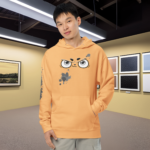 Modelo masculino usando la sudadera Splash Paint amarilla en una galería o museo, destacando su relación con el mundo del arte y la expresión creativa.