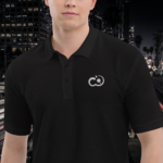 El modelo viste el Polo Premium para hombre Pictonemi Clásico en color negro, mostrando un estilo casual y sofisticado en el entorno urbano de una ciudad.