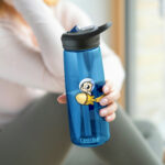 Una mujer artista lleva la botella de agua CamelBak Eddy® ilustrada de Pictonemi, demostrando su utilidad y versatilidad en el mundo del arte.